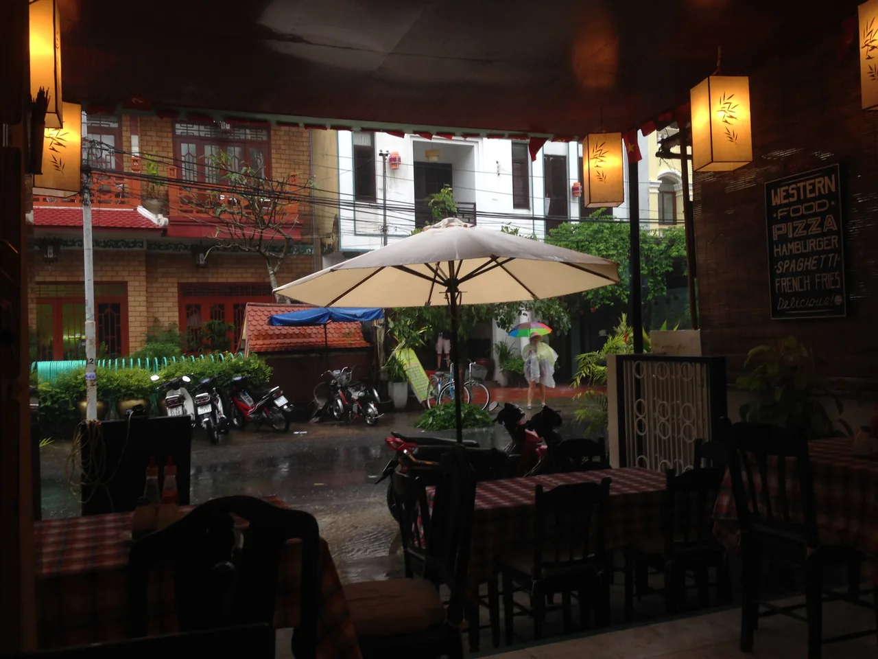 View from a warm cafe onto a rainy Hoi An street