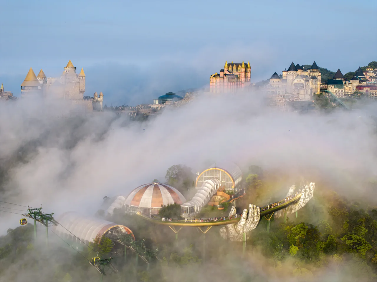The Golden Bridge winding through a morning sea of clouds, with the French Village above the mist