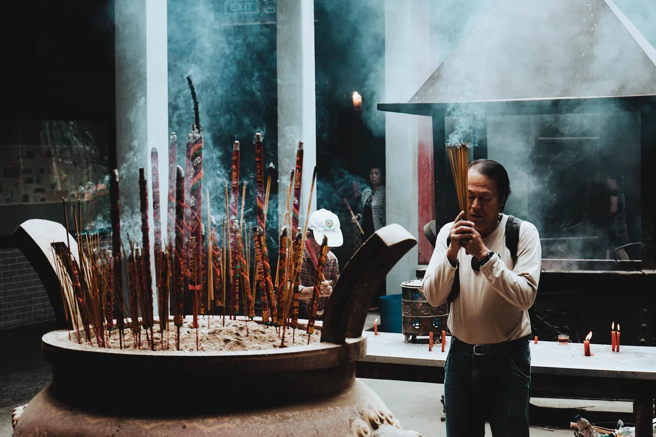 A worshipper offering incense at a Vietnamese Buddhist temple