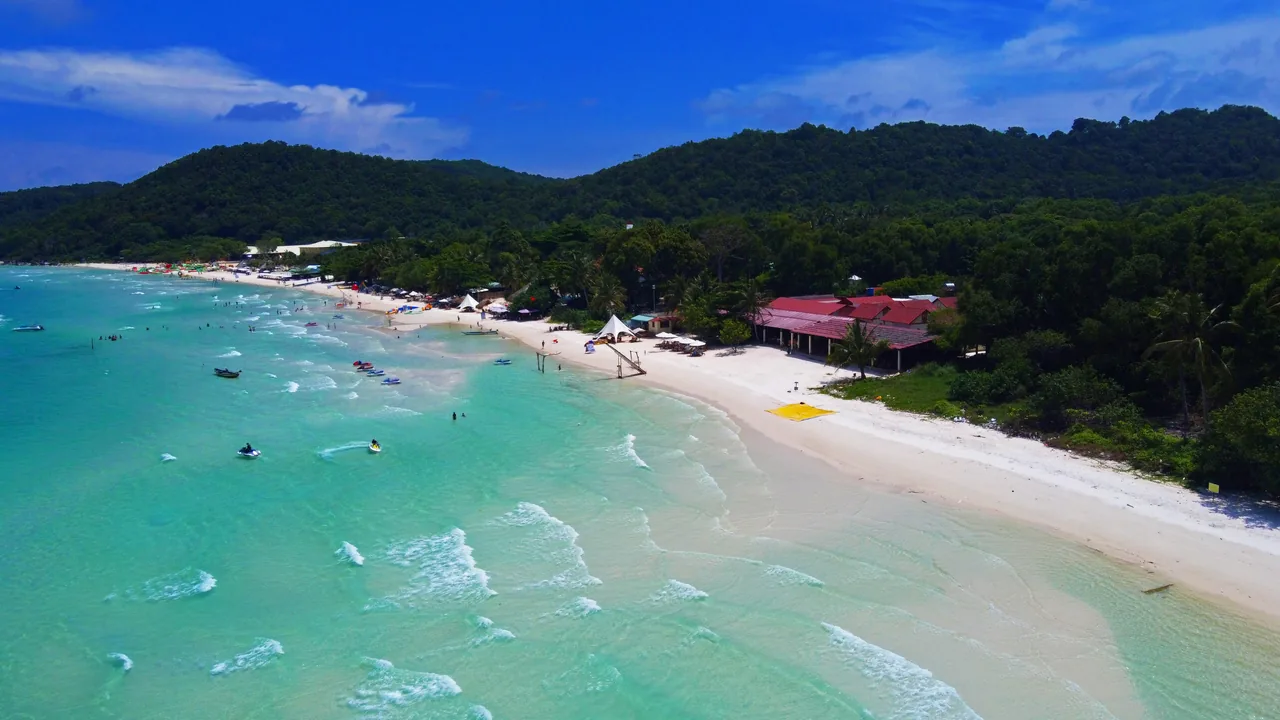 Turquoise tropical bay on Phu Quoc with white sand and a wooded island offshore