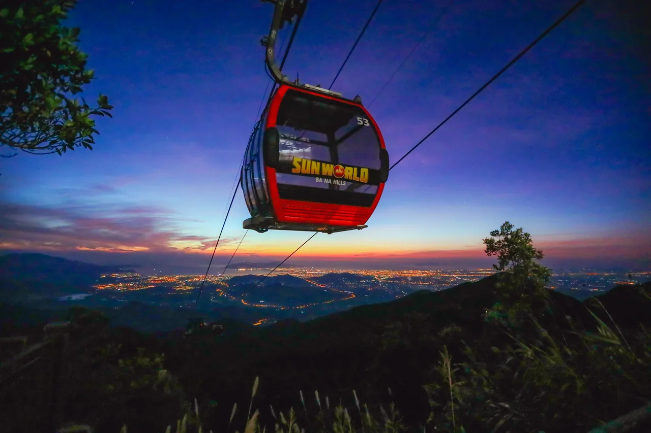 A Sun World Ba Na Hills cable car cabin at night with the lights of Da Nang below