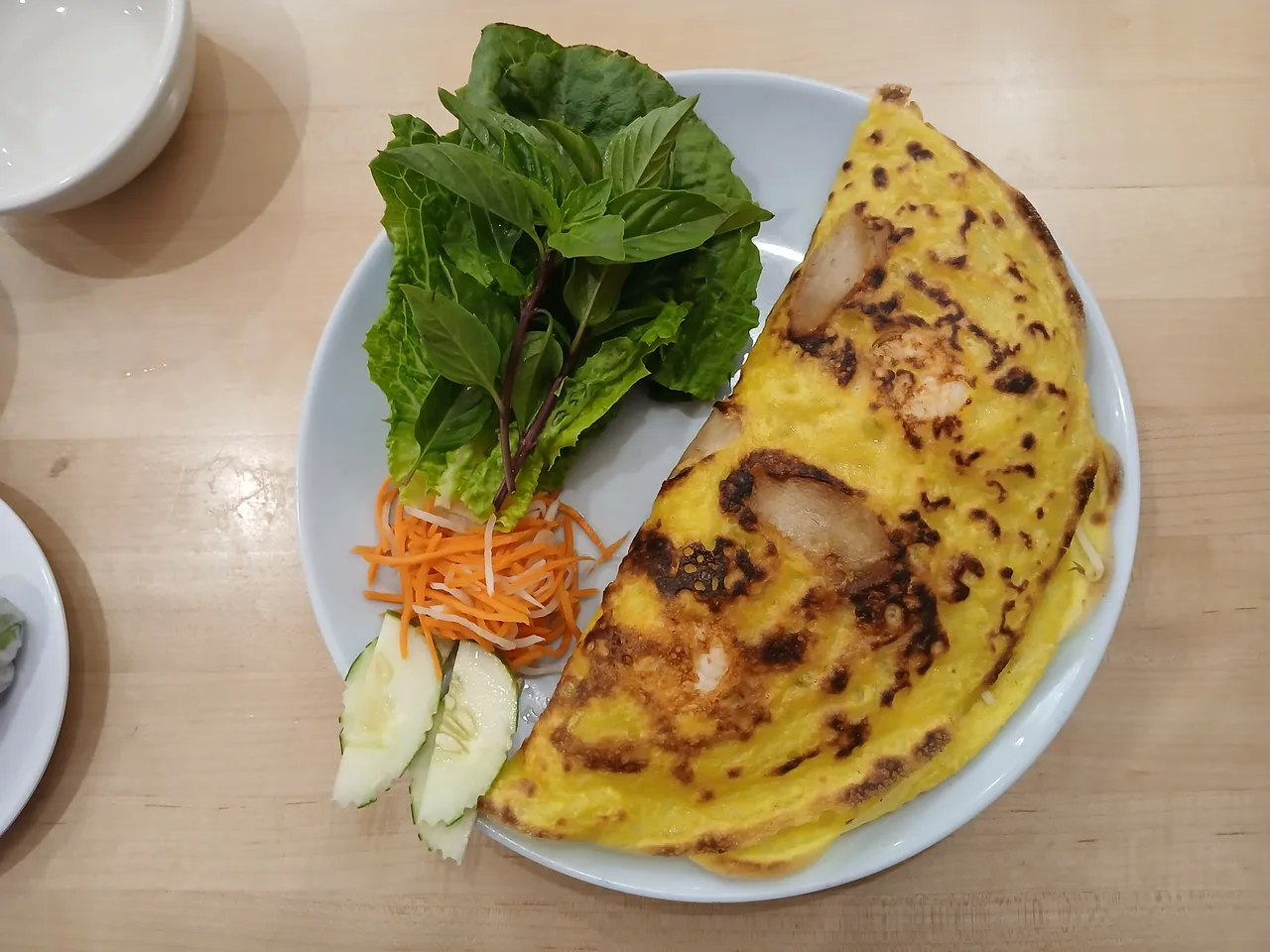 Banh xeo, a crispy Vietnamese turmeric pancake with shrimp and herbs