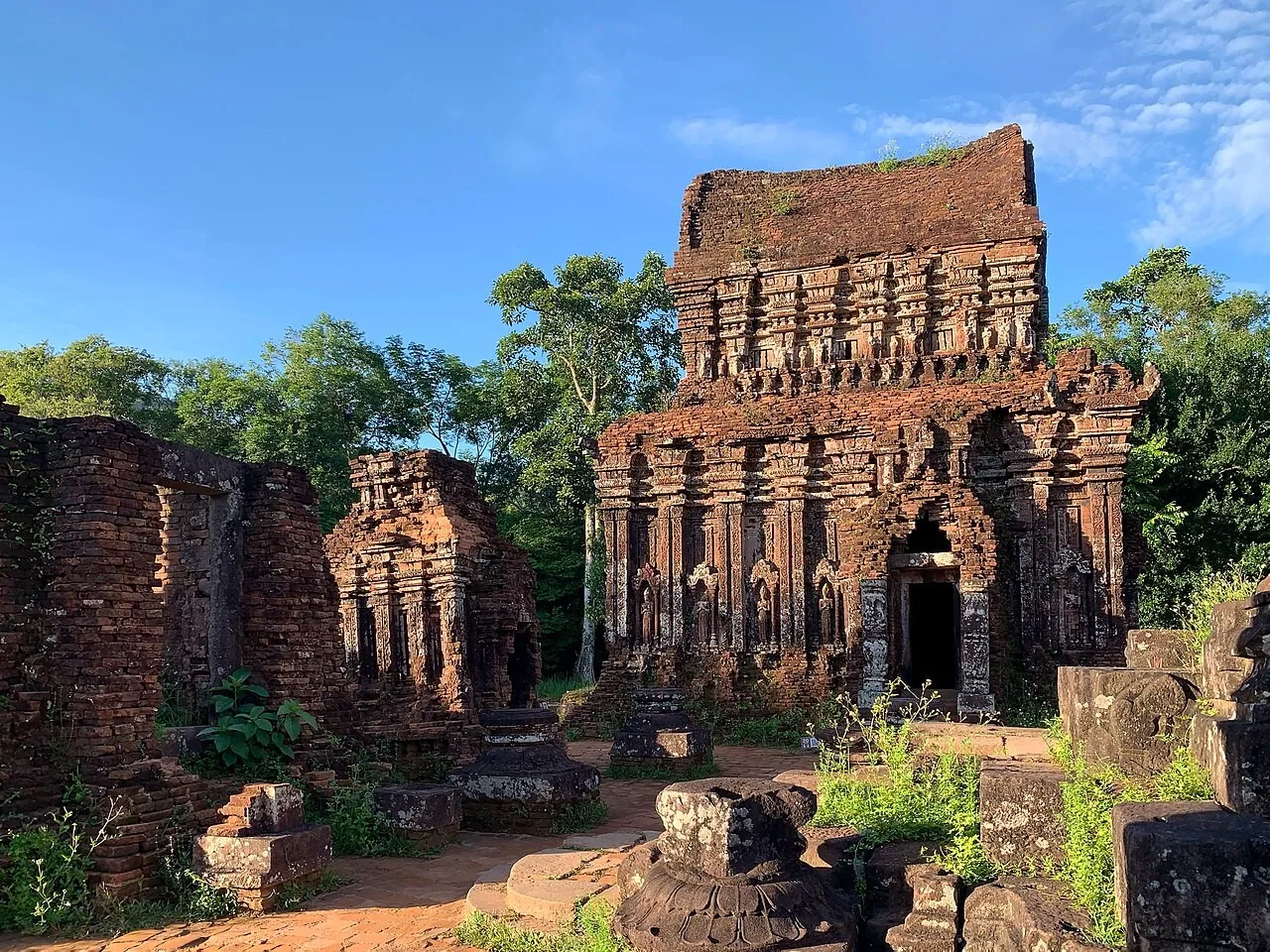 Red-brick Cham towers at My Son standing among trees in low, angled light Red-brick Cham towers at My Son standing among trees in low, angled light