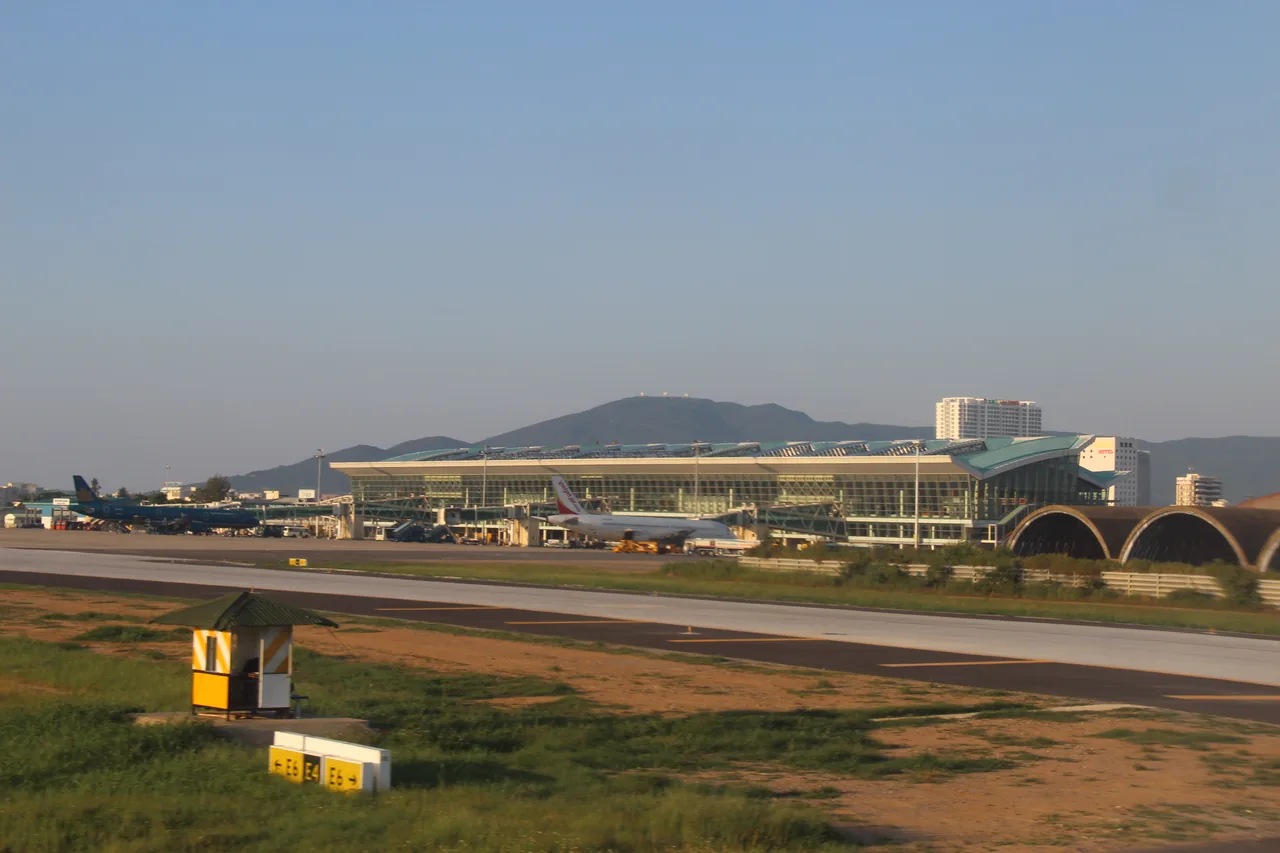 Da Nang International Airport terminal and apron with aircraft and mountains behind
