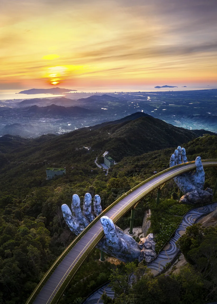 Aerial view of the Golden Bridge at sunset with Da Nang bay in the distance