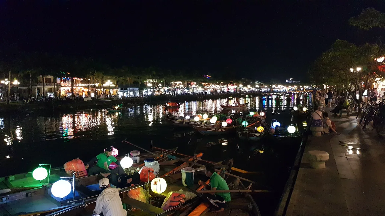 Wooden boats with glowing paper lanterns on the Thu Bon River in Hoi An at night