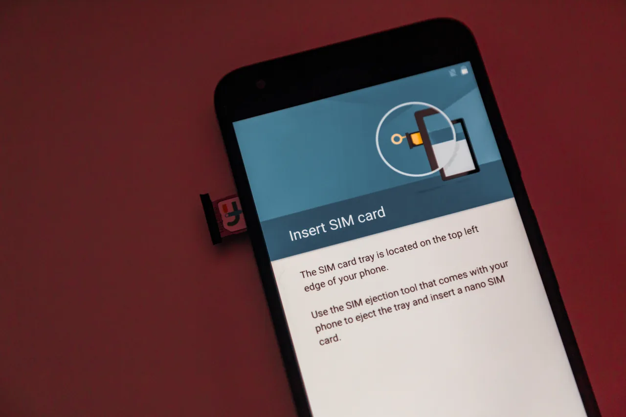 A smartphone with its SIM card tray ejected and an on-screen 'Insert SIM card' setup guide A smartphone with its SIM card tray ejected and an on-screen 'Insert SIM card' setup guide
