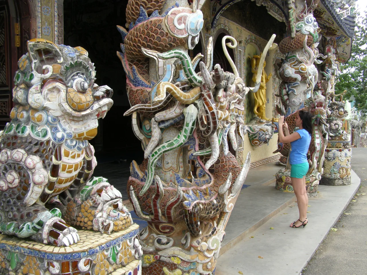 A traveler photographs the mosaic dragon columns of Linh Phuoc Pagoda in Da Lat, Vietnam, with a phone A traveler photographs the mosaic dragon columns of Linh Phuoc Pagoda in Da Lat, Vietnam, with a phone