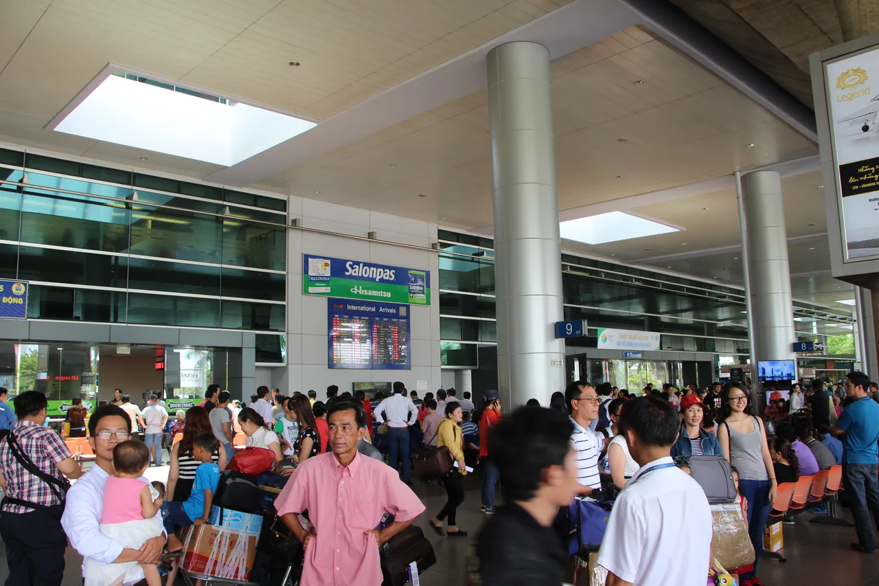 Arriving passengers collecting luggage in an airport arrivals hall
