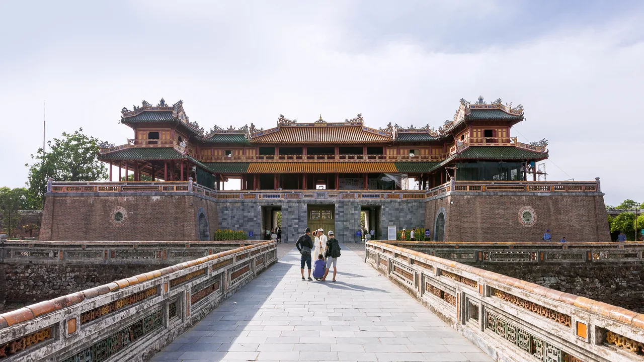 The Ngo Mon gate of Hue's Imperial City reflected in the moat, with the flag tower beyond.
