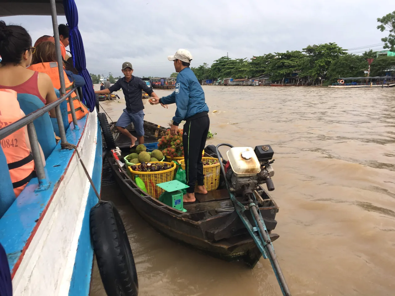 Vendors in conical hats selling produce from wooden boats at the Cai Rang floating market at dawn on the Mekong.