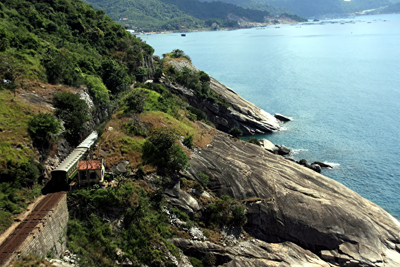 A Vietnamese passenger train on the coastal cliff line above the South China Sea