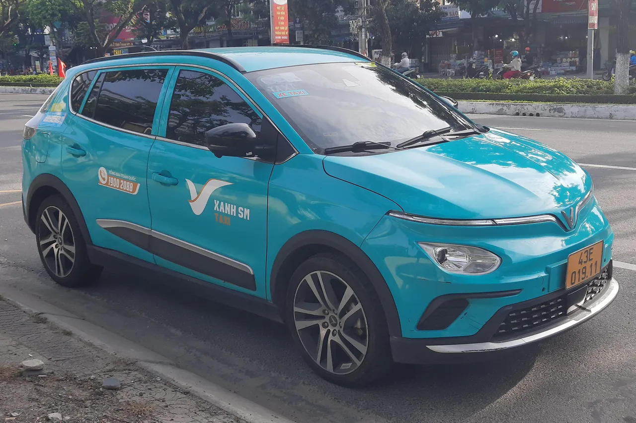 A bright-green Xanh SM electric taxi, common in Da Nang