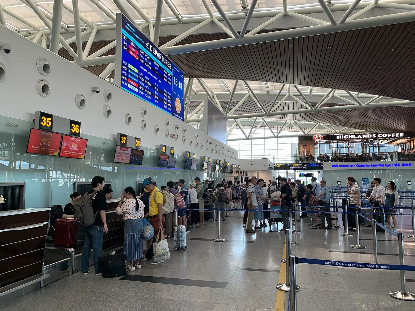 Check-in counters 35 and 36 in the international terminal at Da Nang airport, with the departures board overhead and passengers waiting with their luggage