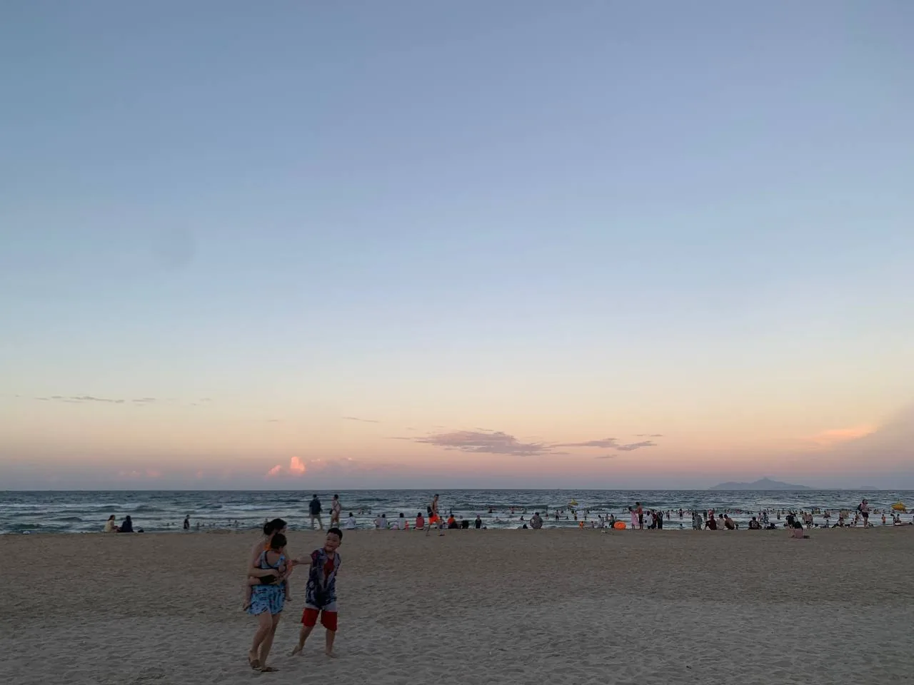 My Khe beach in Da Nang in the early morning with people in the water and along the sand