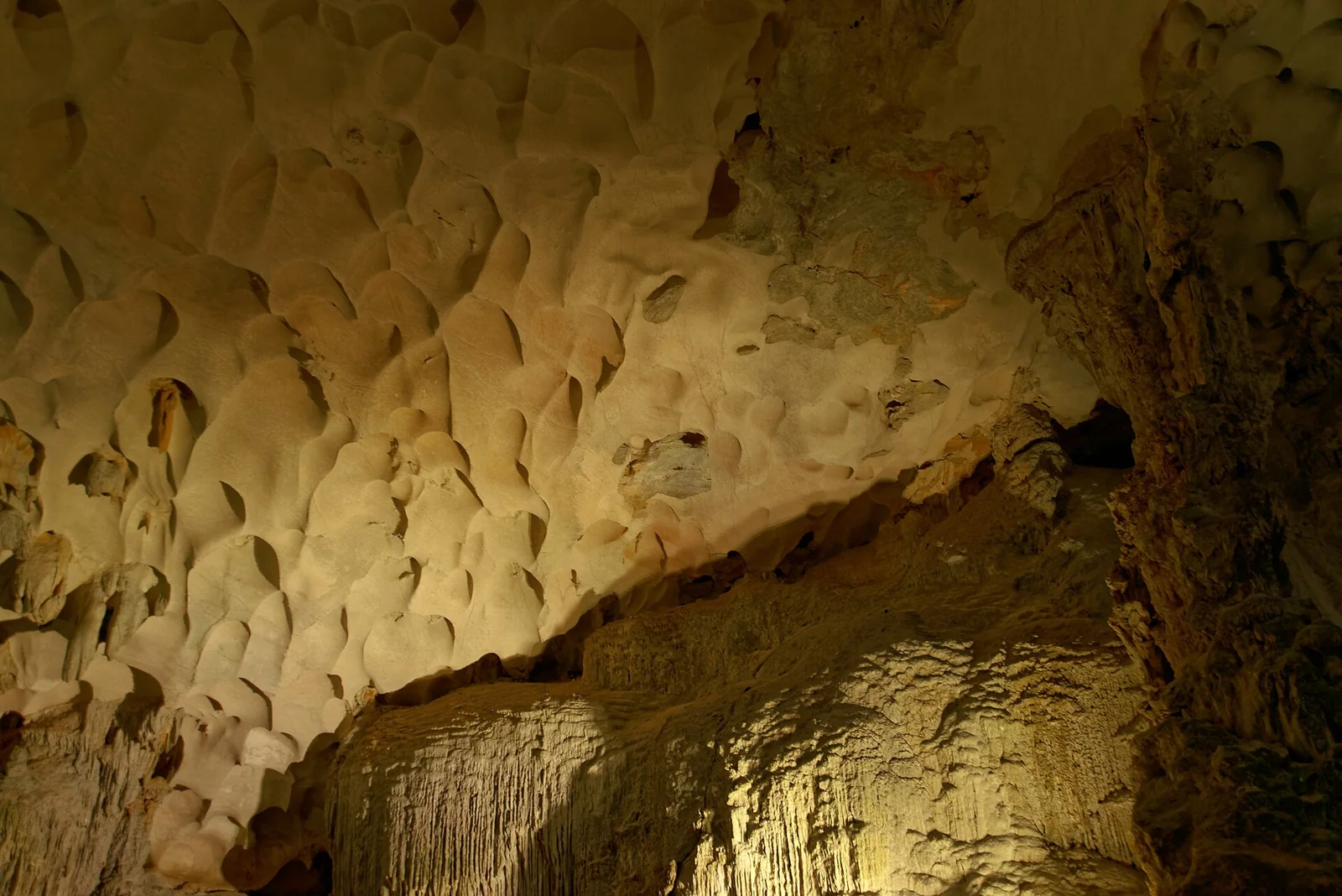 Lit stalactites and rock formations inside Sung Sot cave in Ha Long Bay