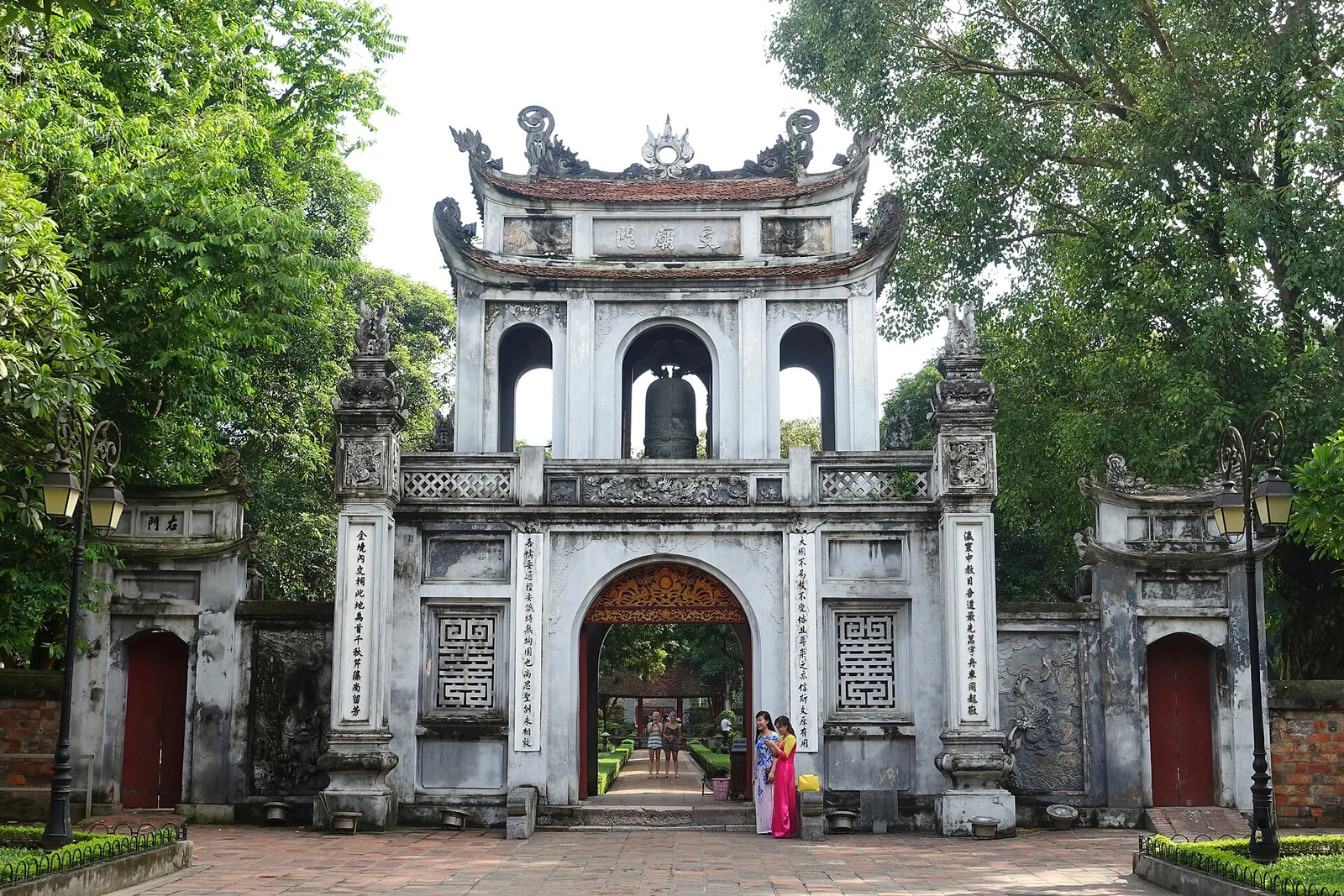 The tiled main gate and stone pillars of the Temple of Literature in Hanoi seen from the street