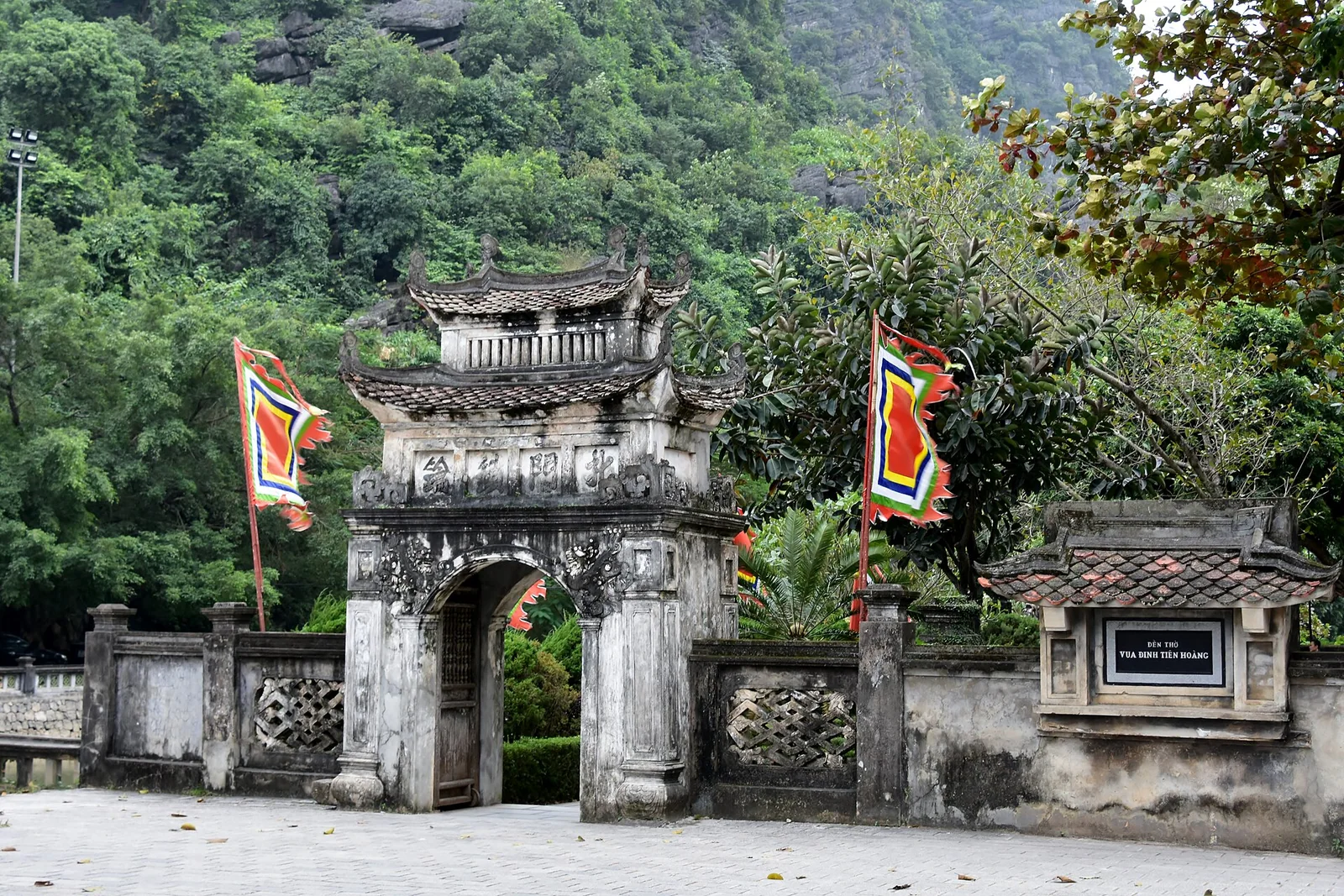 The old stone gate of Hoa Lu, the former capital of Vietnam, with flags flying above it