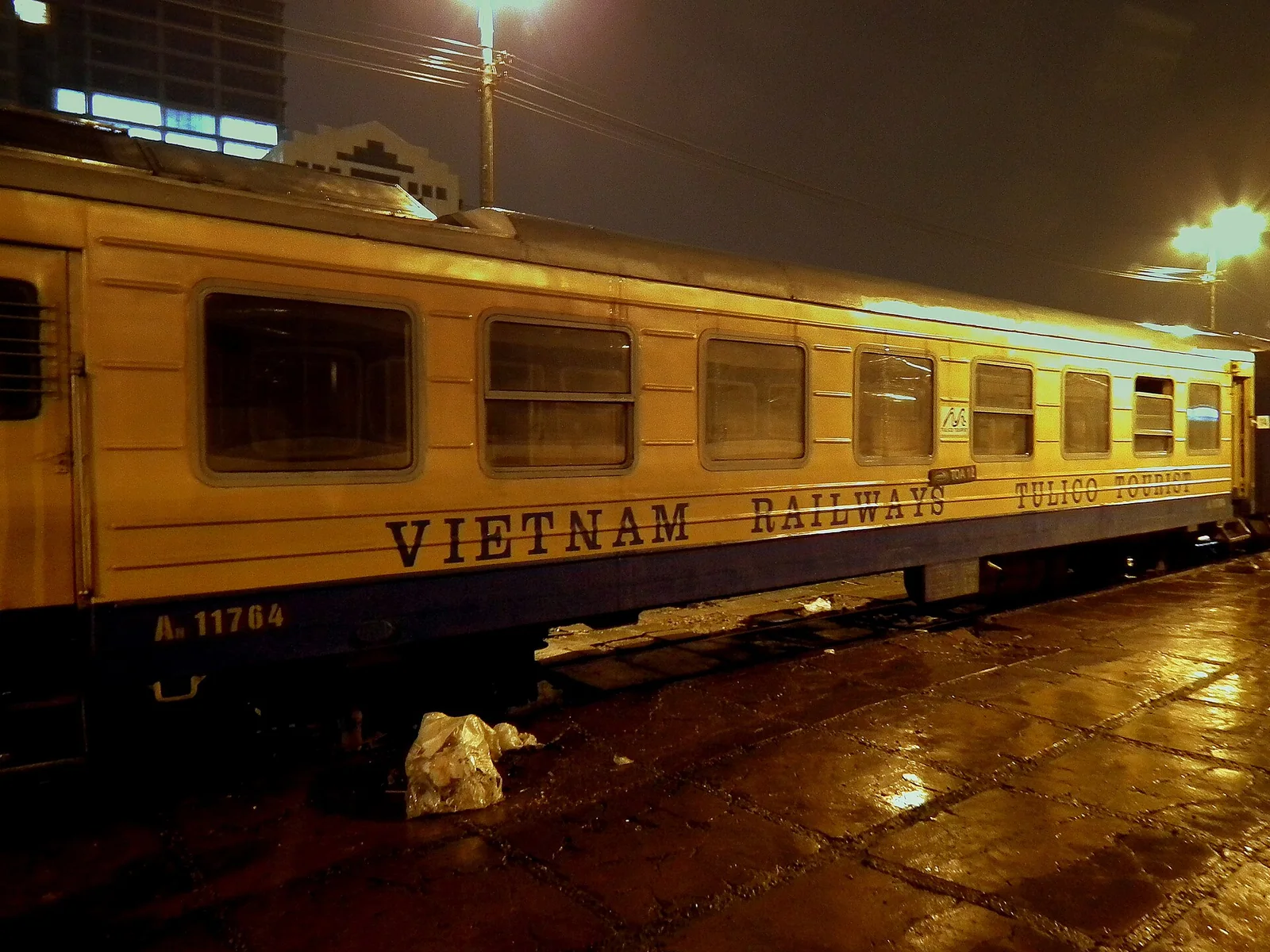 A Vietnam Railways sleeper carriage stopped at a platform at night