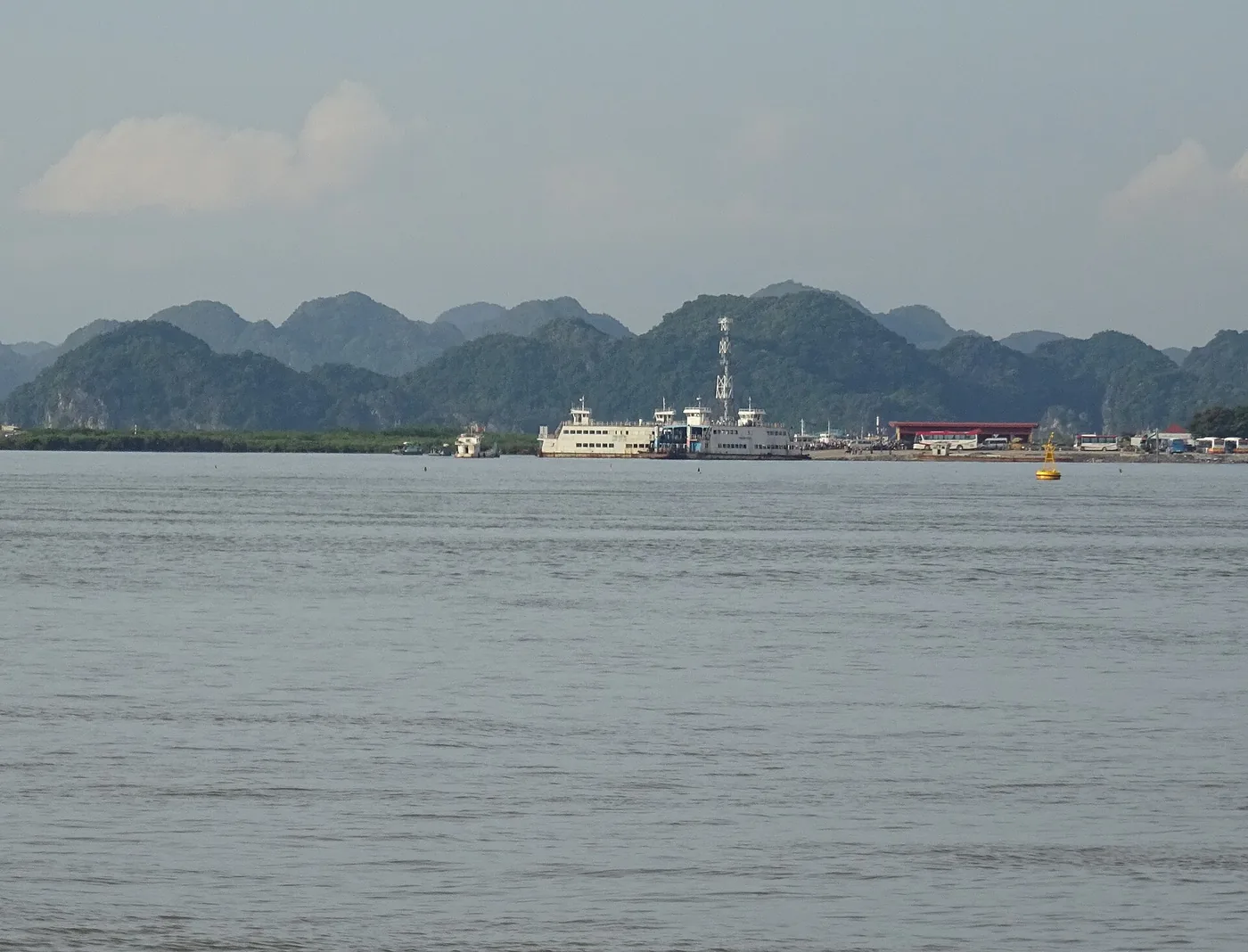 海の向こうに見える桟橋と、その前に停泊した白い旅客船 海の向こうに見える桟橋と、その前に停泊した白い旅客船