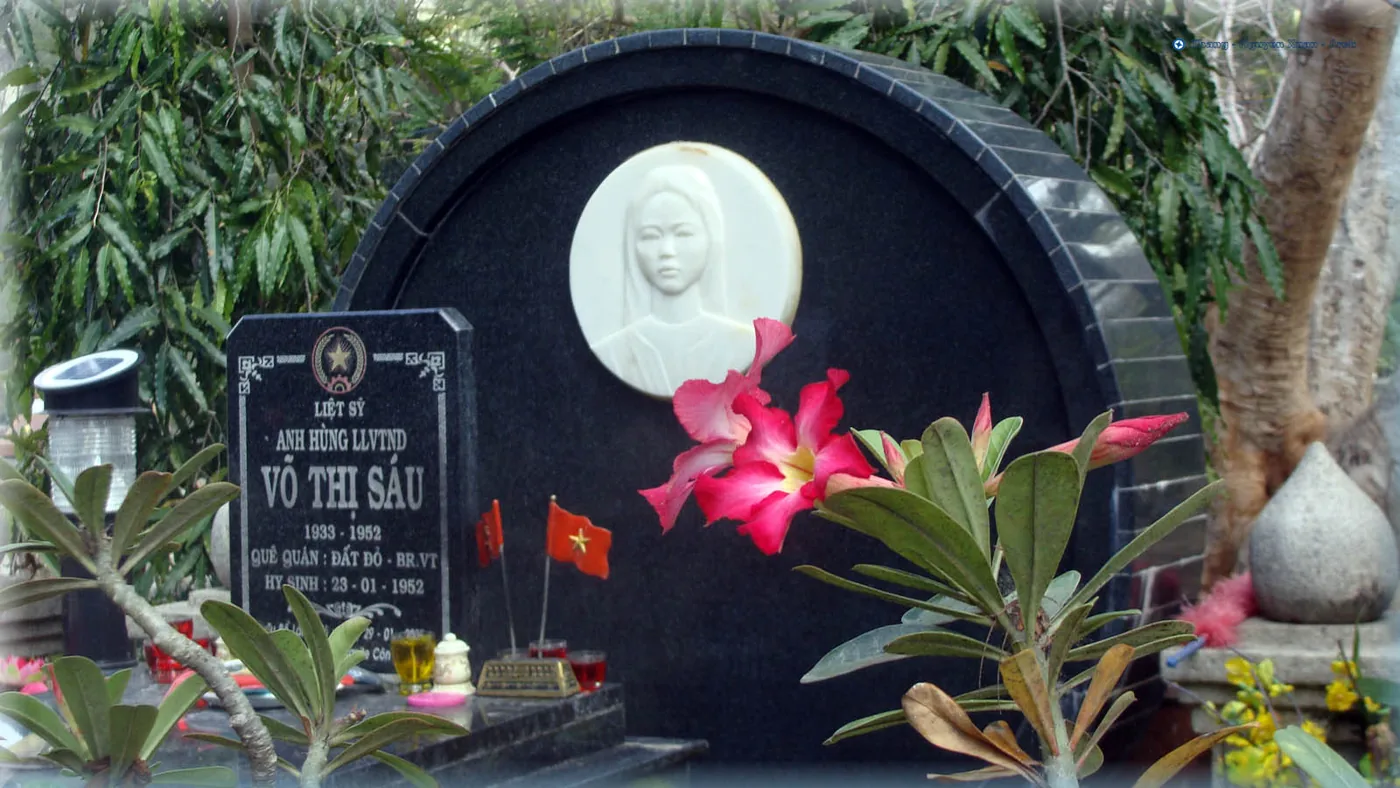 The grave of Vo Thi Sau with flowers and incense laid in front of it