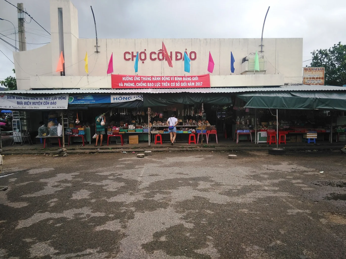 Stalls and plastic chairs set out in front of the Con Dao market building