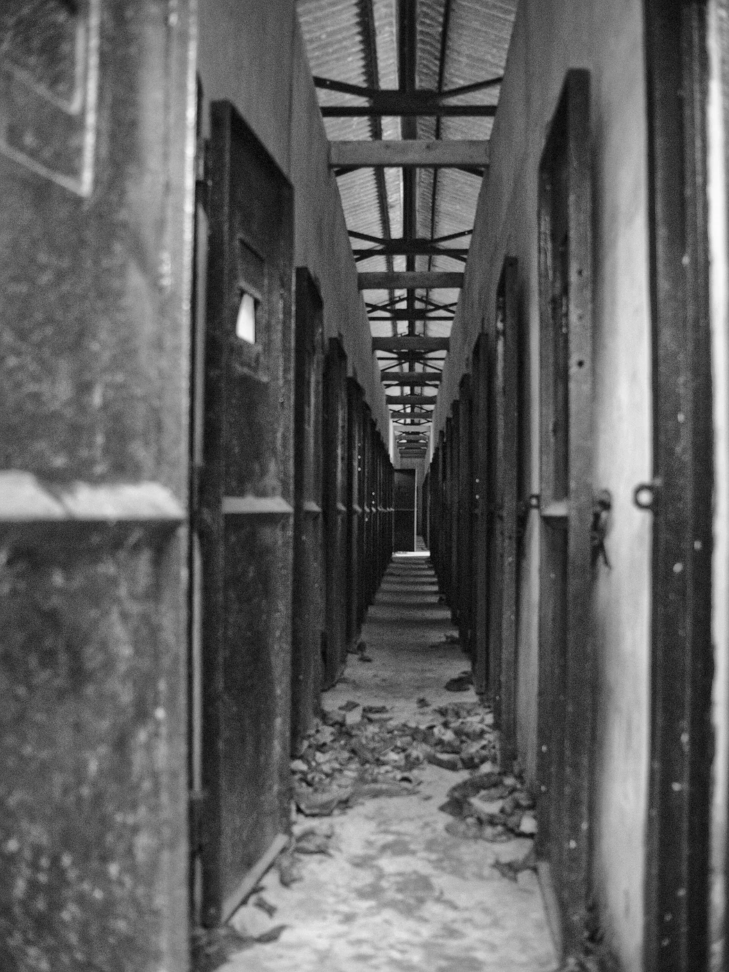 A long narrow corridor inside Con Dao prison with cell doors down both sides