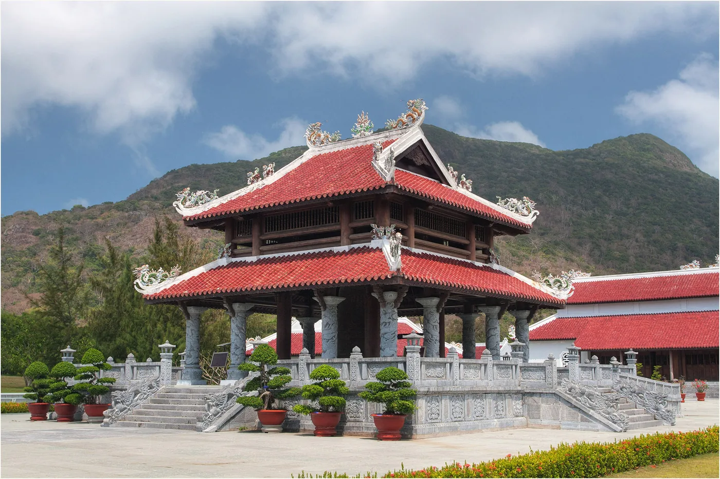 The red-tiled roof of the Con Dao memorial temple above a stone staircase