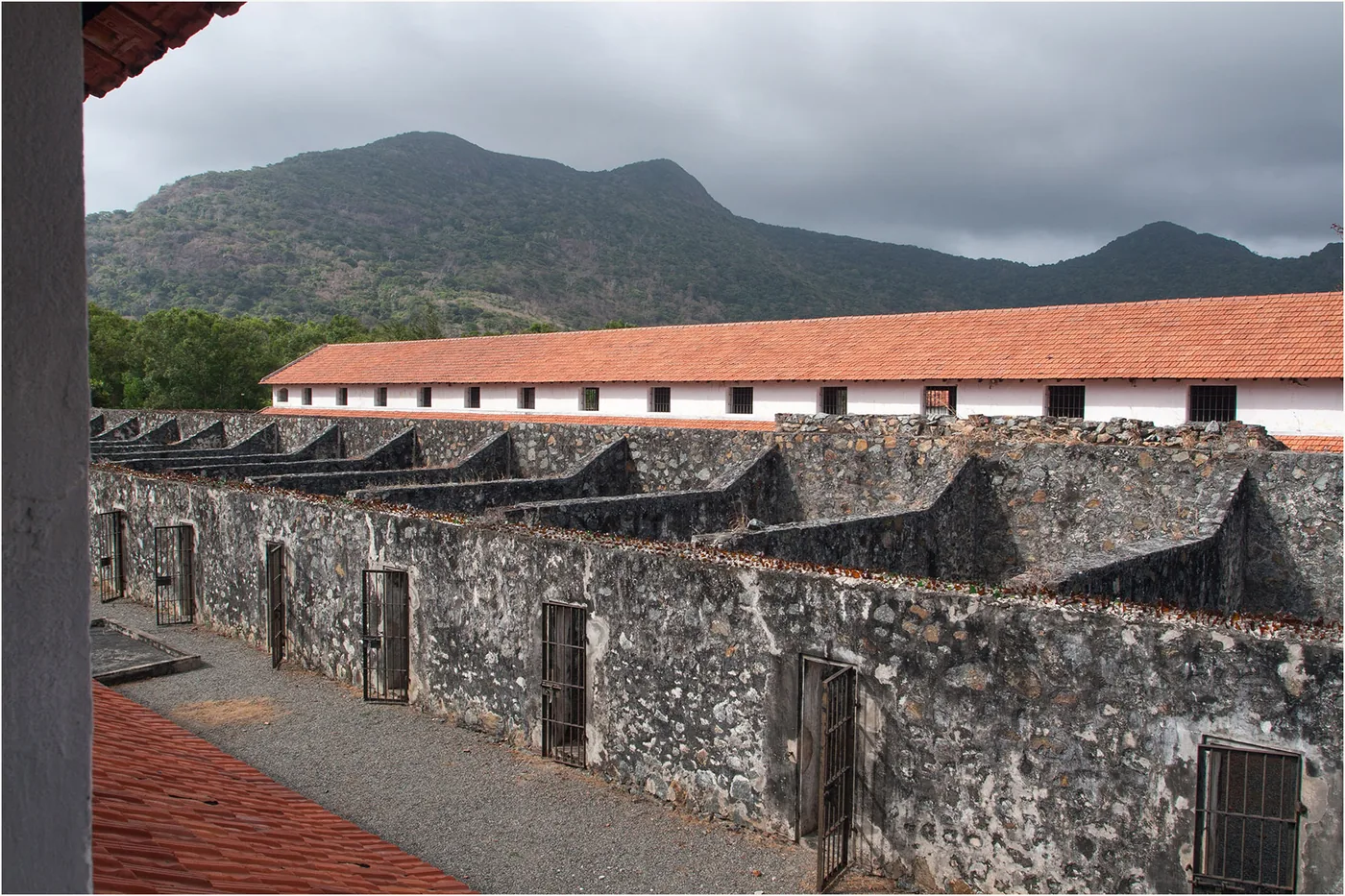 Stone-walled compartments of the French tiger cages with hills in the background
