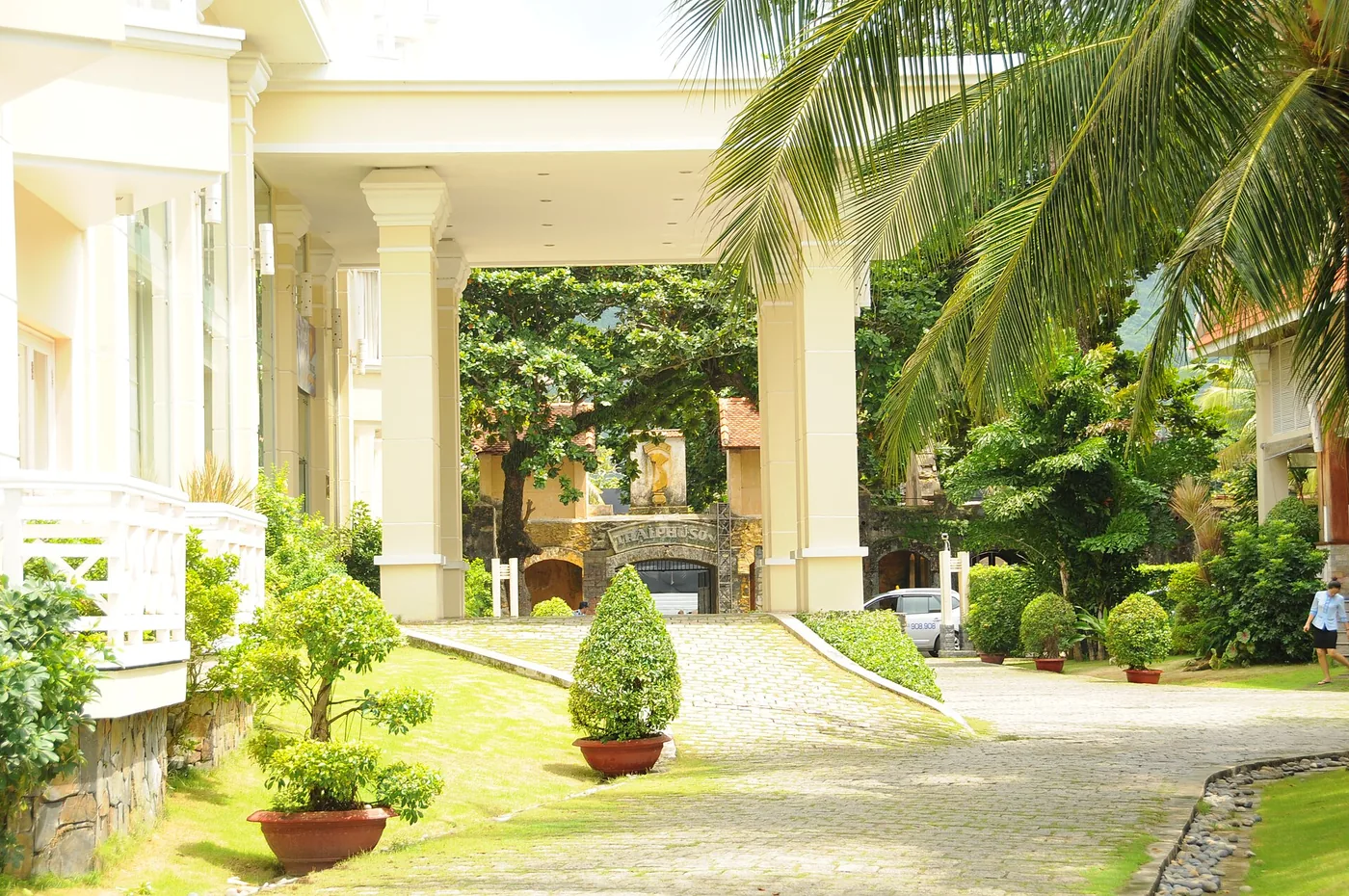 The colonnaded front entrance of Saigon Con Dao Resort with a garden in front