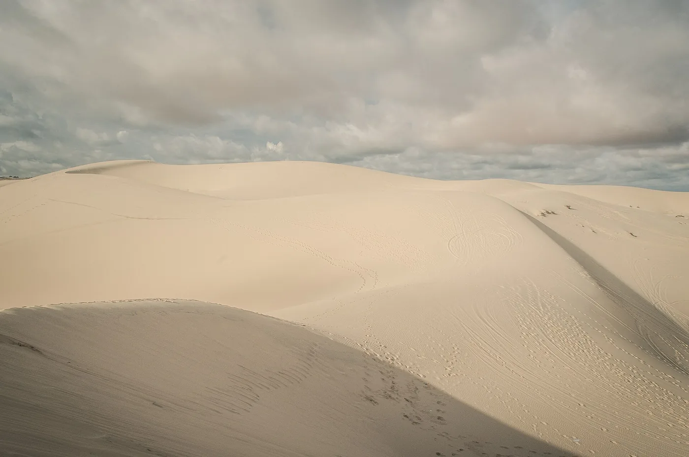 The pale ridge of the white sand dune near Bau Trang under an overcast sky The pale ridge of the white sand dune near Bau Trang under an overcast sky