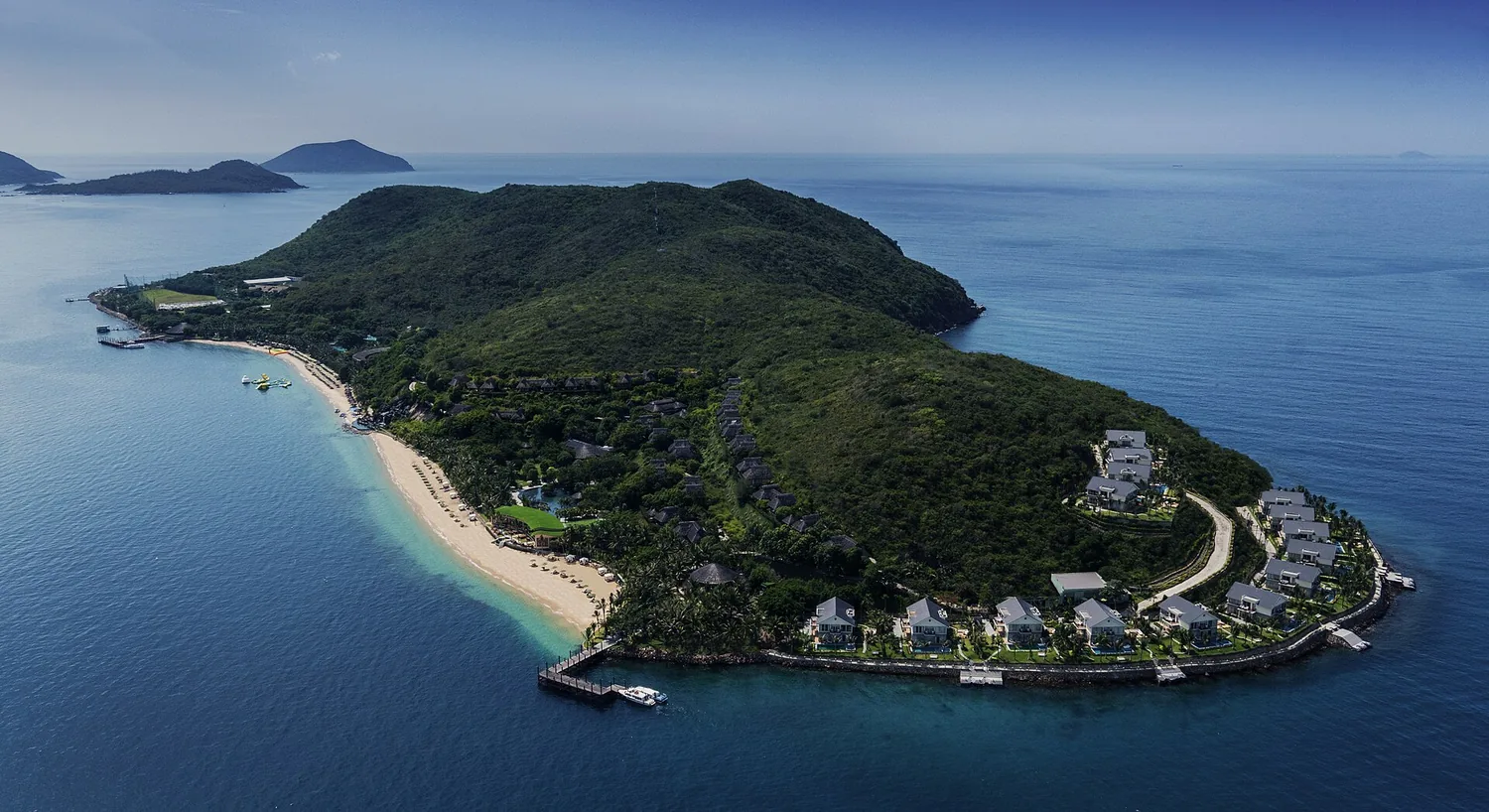 上空から見たホンタム島。緑の丘と海岸沿いの低いヴィラ、桟橋 上空から見たホンタム島。緑の丘と海岸沿いの低いヴィラ、桟橋