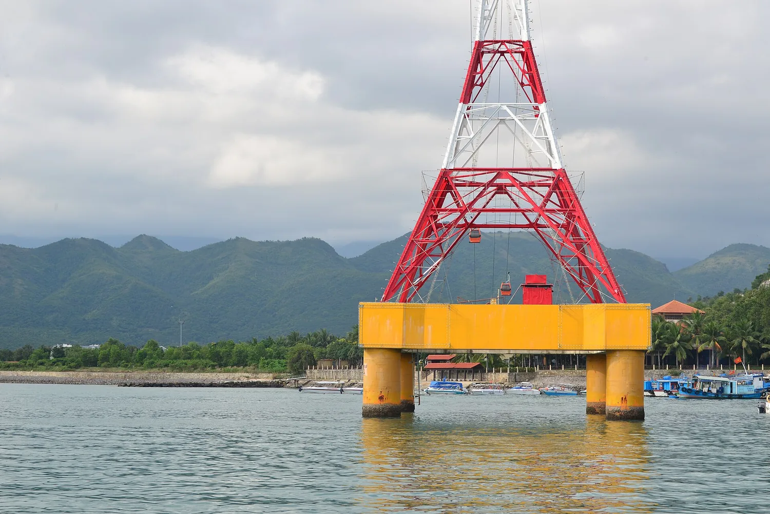 海の中の黄色い基礎の上に立つ赤と白のケーブルカー鉄塔 海の中の黄色い基礎の上に立つ赤と白のケーブルカー鉄塔