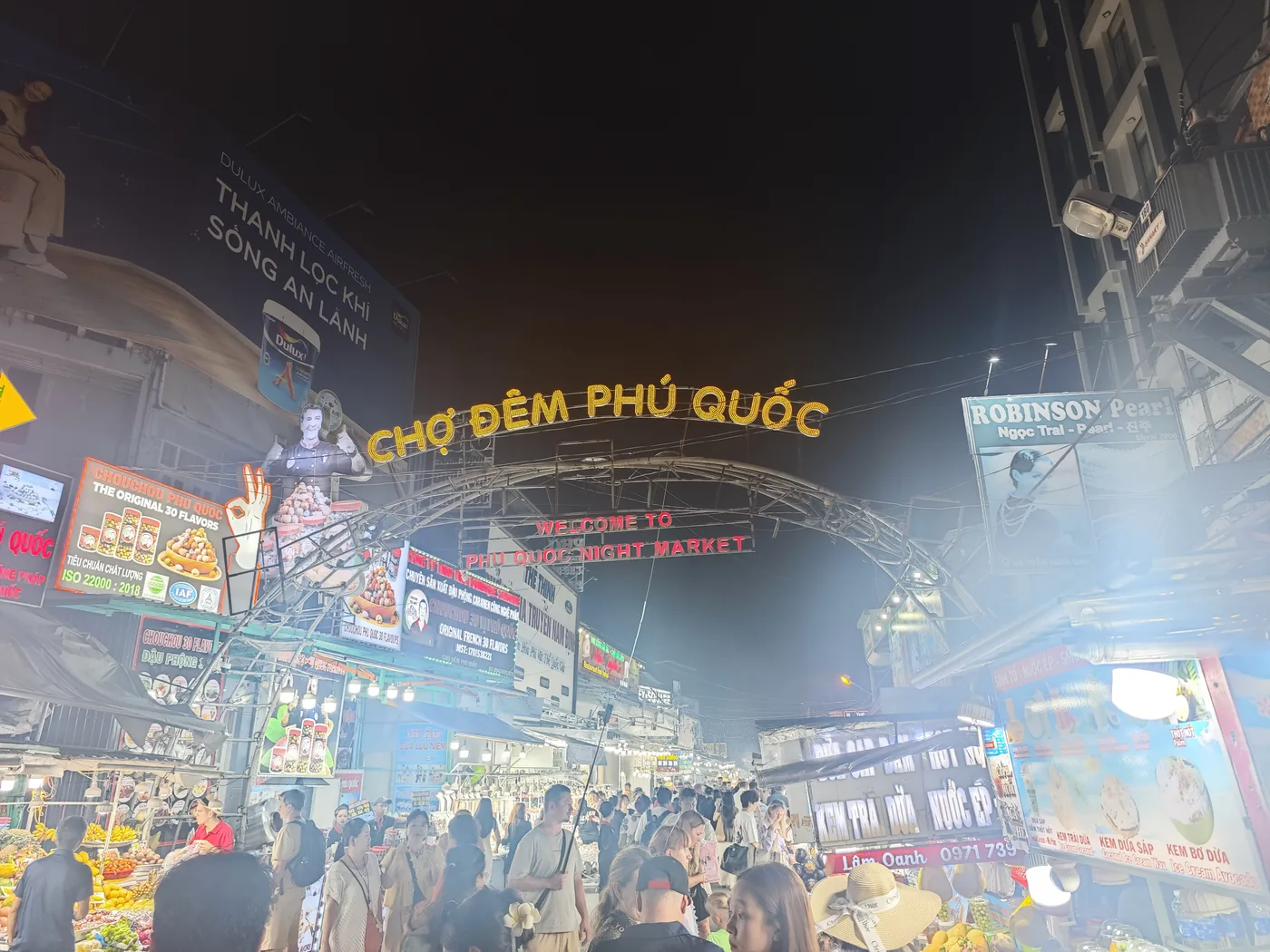 晚上亮燈的「CHỢ ĐÊM PHÚ QUỐC」拱門,下面的街道擠滿人 晚上亮燈的「CHỢ ĐÊM PHÚ QUỐC」拱門,下面的街道擠滿人